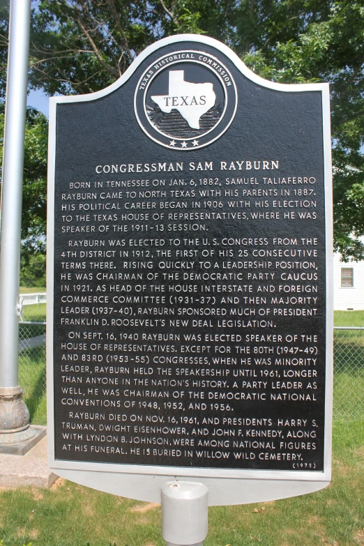 a sign sitting on top of green grass covered ground