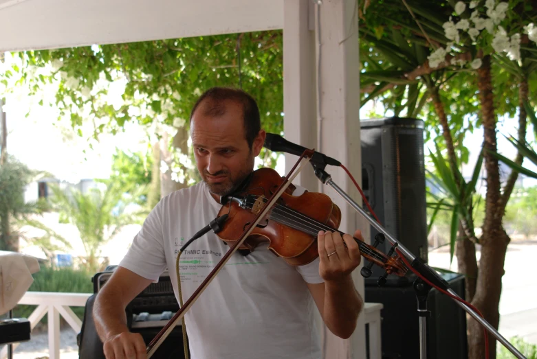 a man holding a violin while playing on a stage