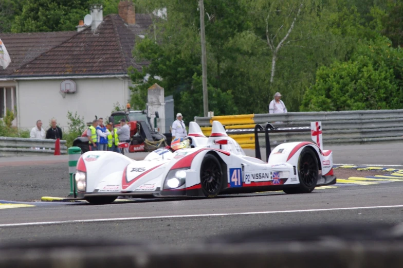 the white and red race car has passengers sitting on top