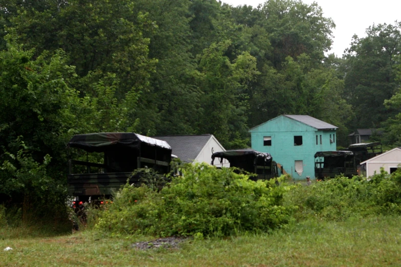 an old blue house sits in the woods