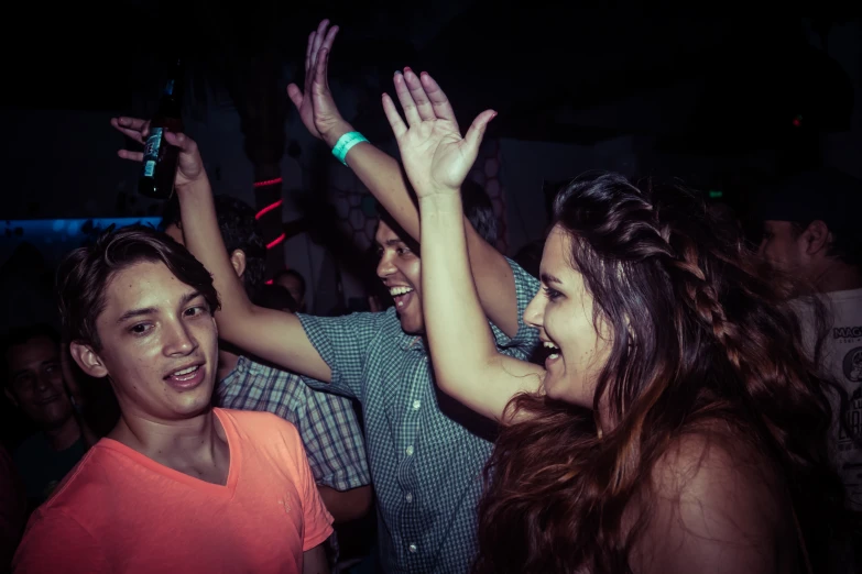 group of people are smiling and reaching their hands