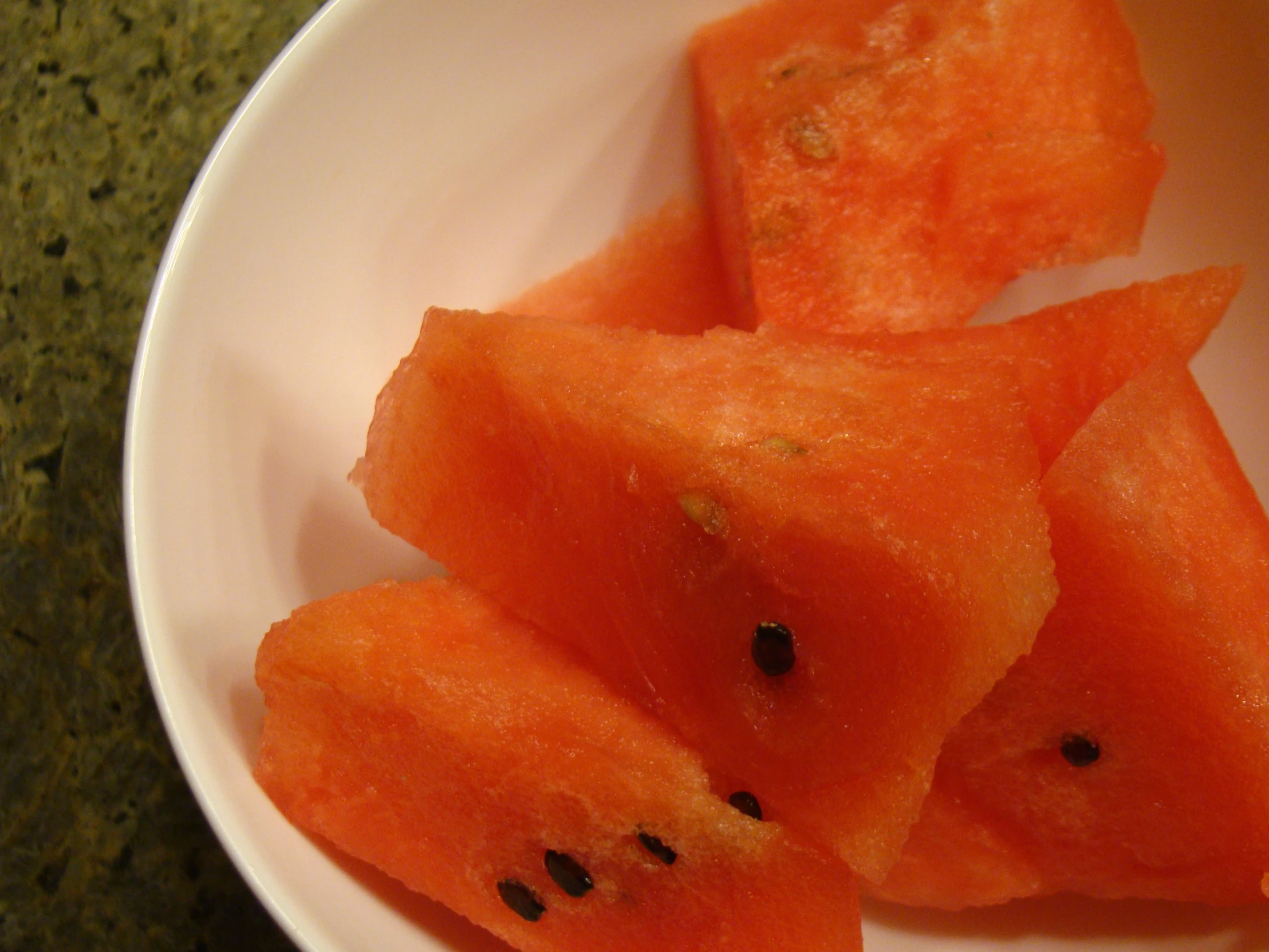 a white plate with several pieces of cut up watermelon