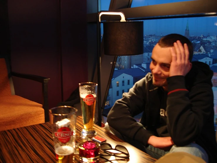a man wearing glasses sitting in a bar