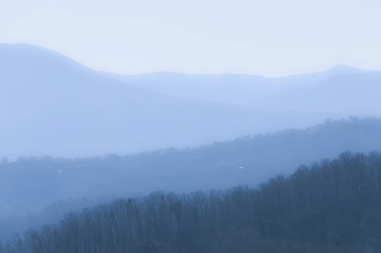 some hills and trees on a foggy day