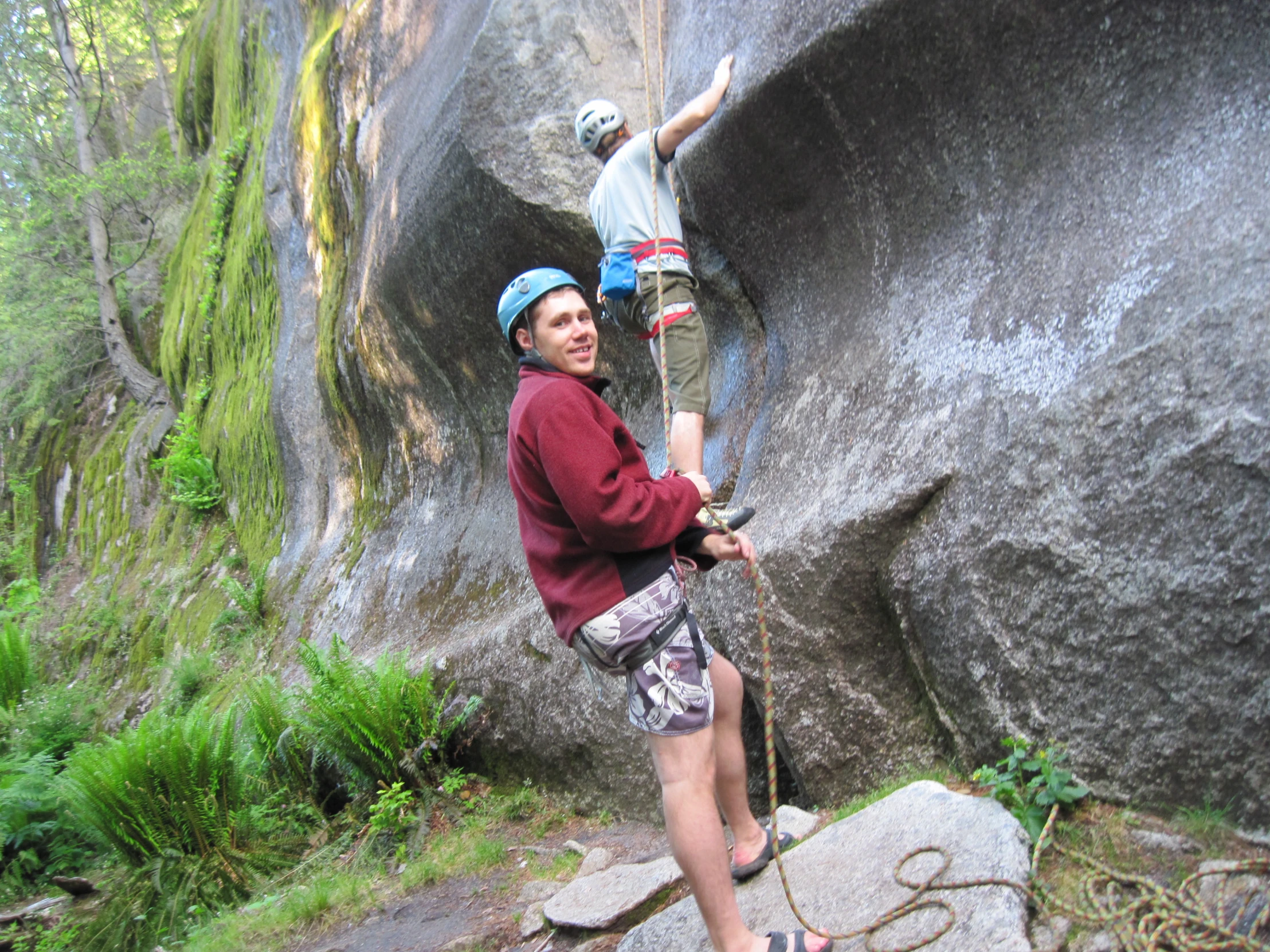 a man climbing up a rock face while holding onto the rope