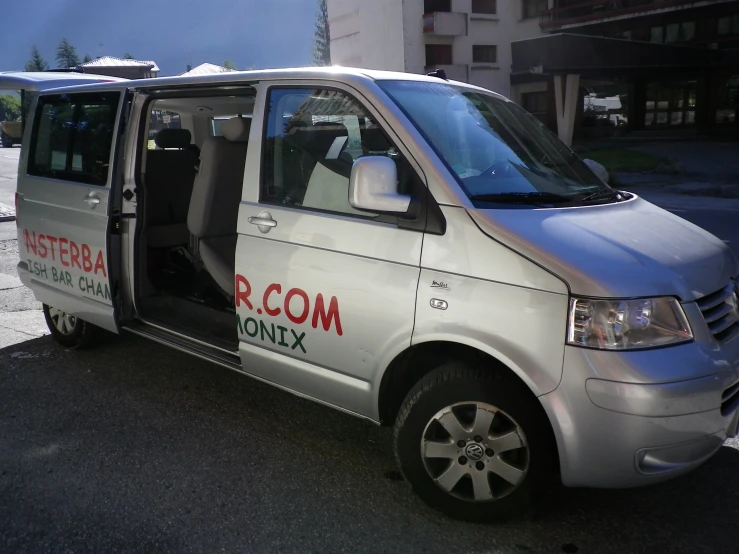 a silver van parked on top of a city street