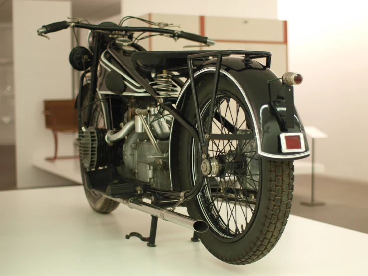 an old model motorcycle sits on display in the museum