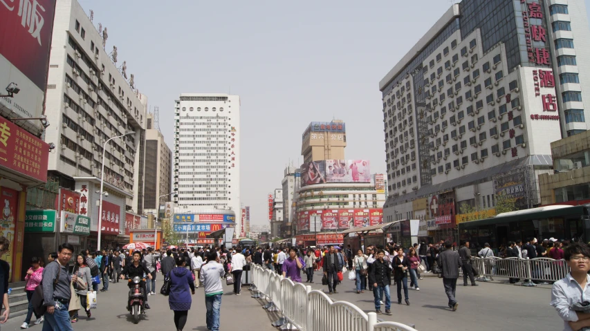 a bunch of people are walking in a big city