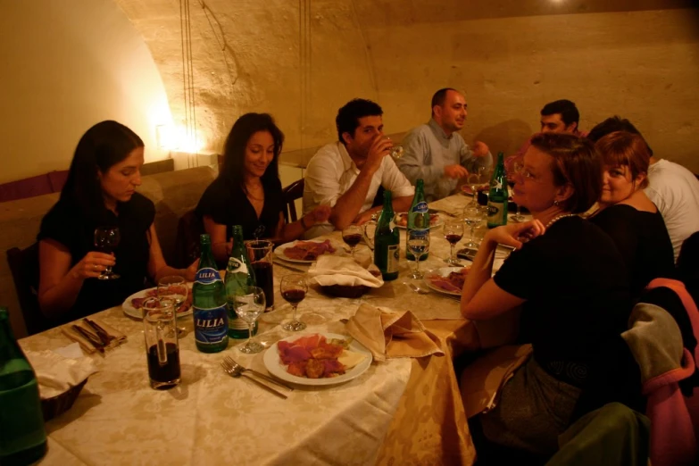 group of people sitting at dinner table with glasses