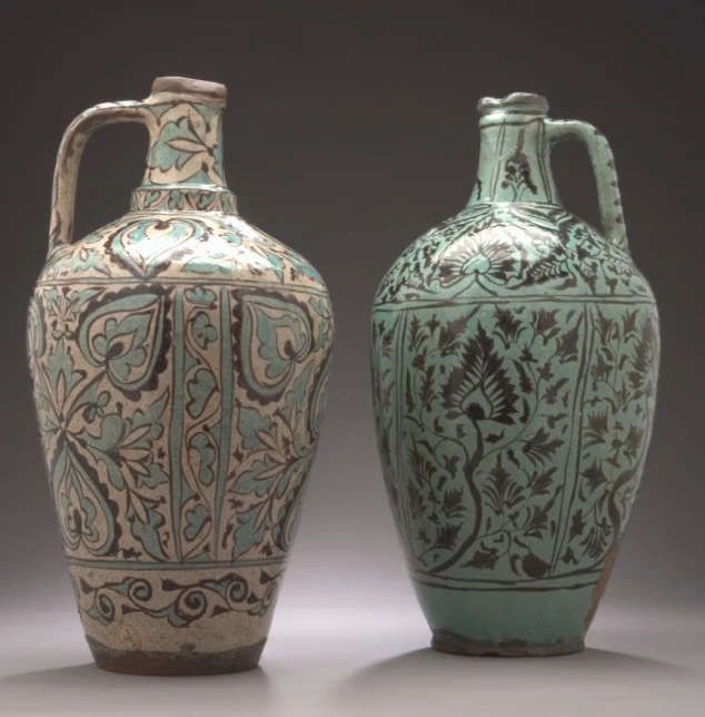 two old pottery style vases on display against a grey background