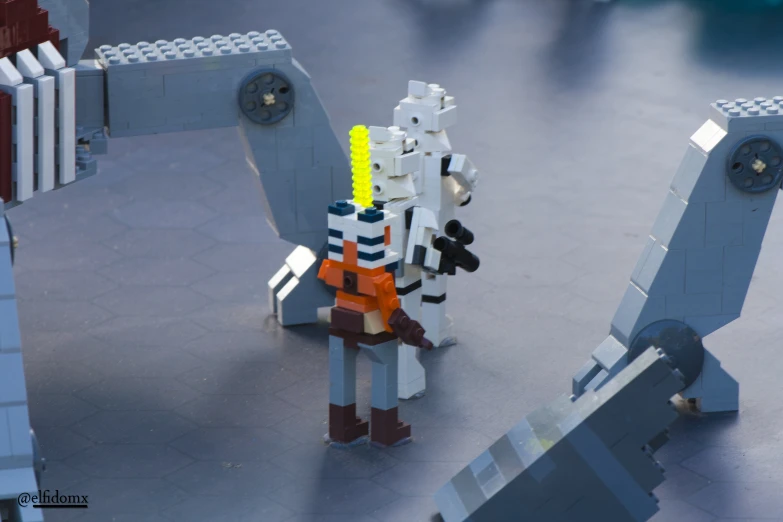 lego architecture showing a robot with a rifle standing next to a dog and other items