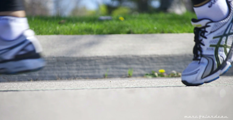 a man in black and white running shoes near grass