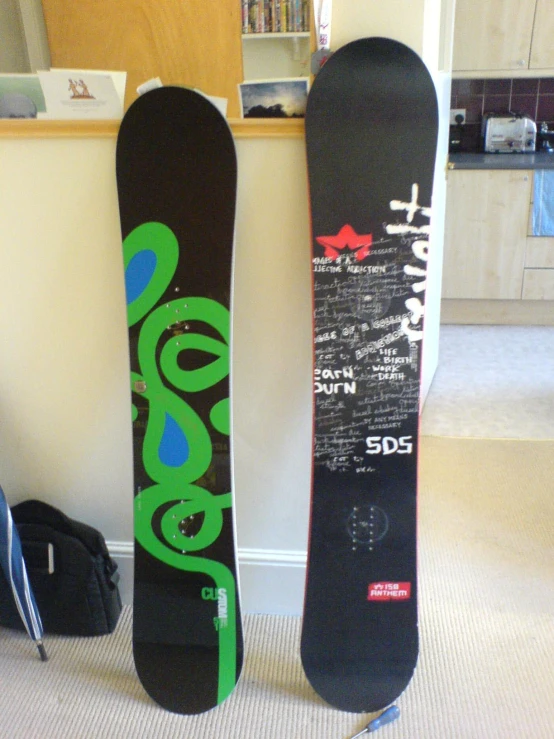 two snowboards leaning against a wall in the corner of a room