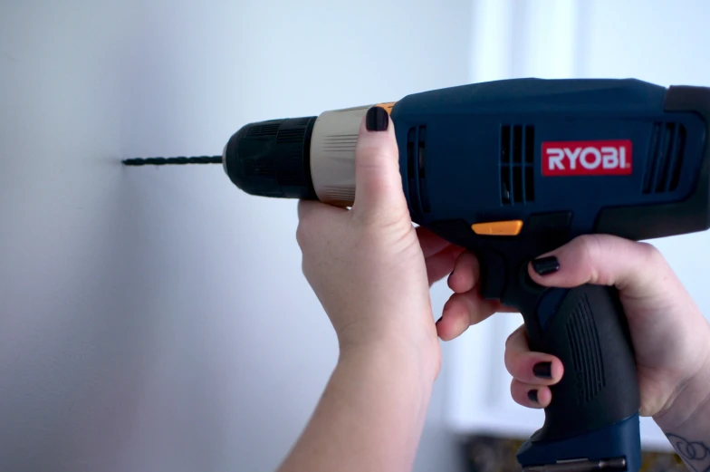 a person holds an electric drill in their hand