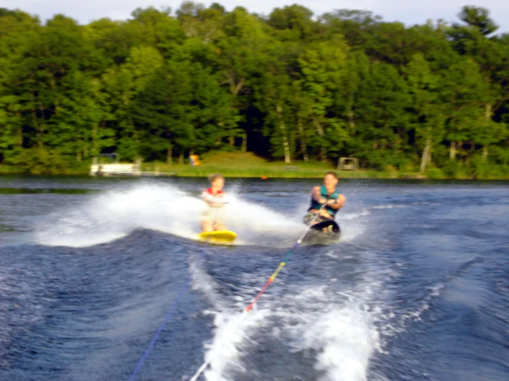 two people skiing on the water and one holding a rope