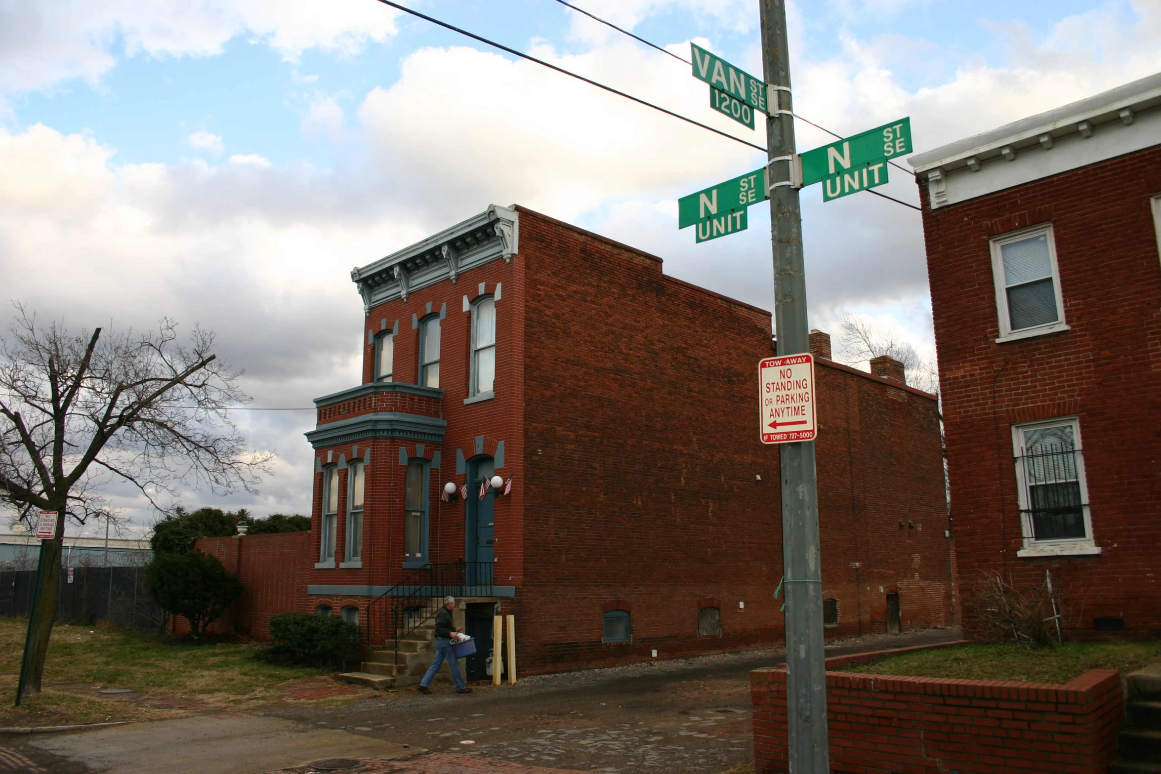 two green street signs on the side of a brick building