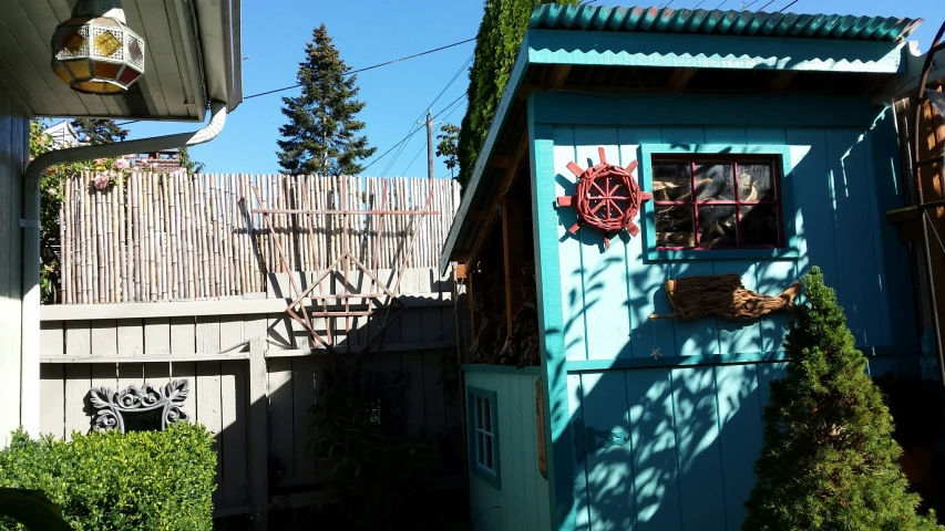 a small building sitting next to a tall white fence