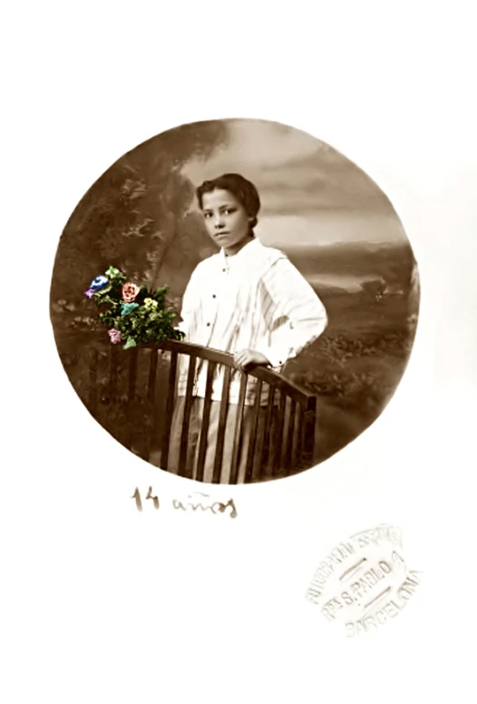 a boy in white standing with his arms on a railing