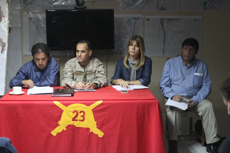 some people sitting at a table signing paperwork