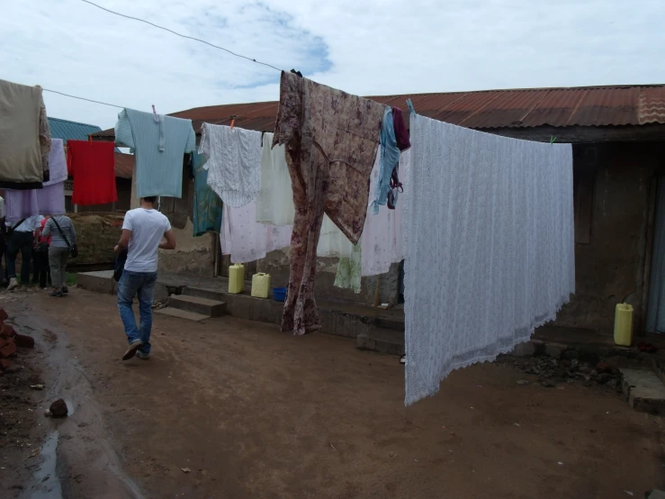 clothes are hung on clothes line by a small dirt road