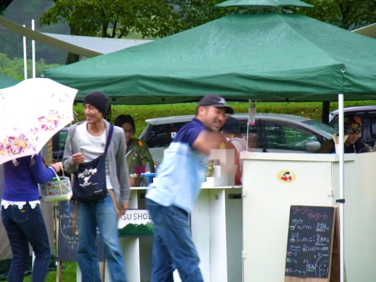 group of people at outdoor food stand with umbrellas