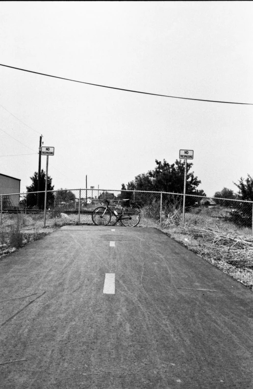 a person riding a bike down a street past a fence