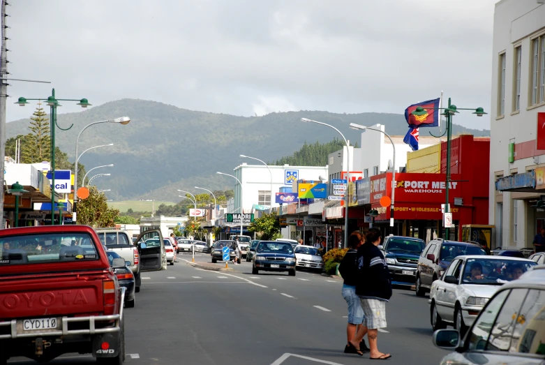 cars are driving down a city street during the day