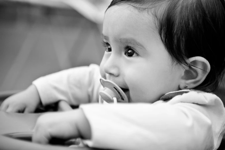 the baby is chewing on a bottle in her mouth