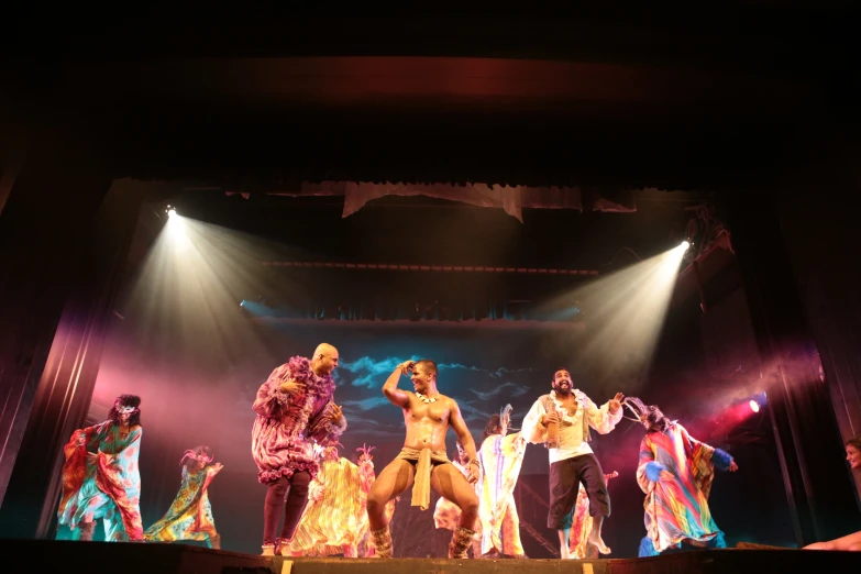 performers on stage on a dark night with bright colored lighting