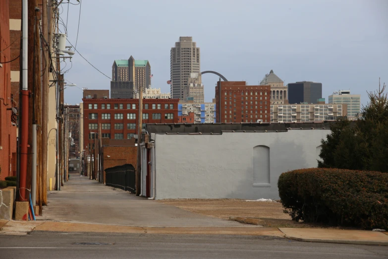 an urban skyline view is shown from an alleyway