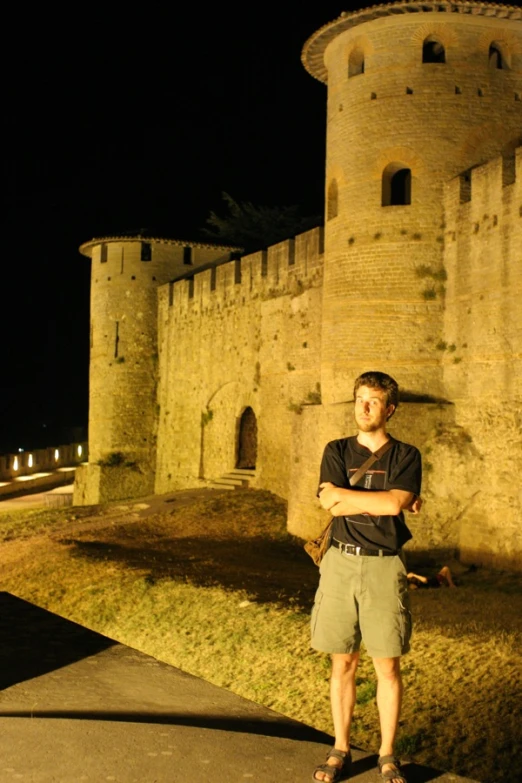 young man standing in front of an old castle