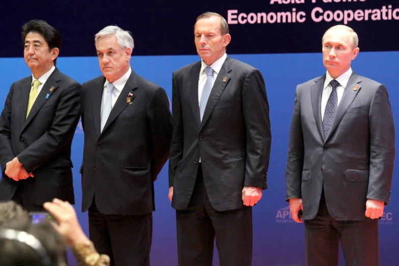 three men in business suits are speaking at the asia pacific economic conference