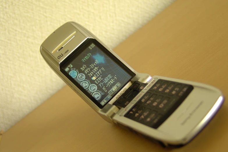 an open flip phone on a table with a brown counter