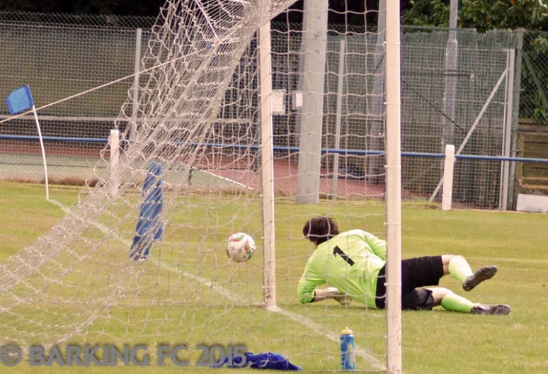 a soccer player on the field has fallen over as he rests