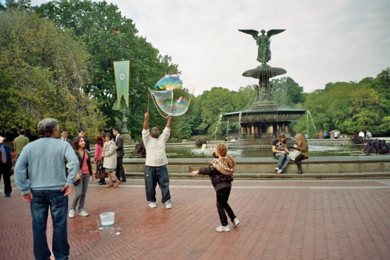 some people are outside playing with bubbles in the city