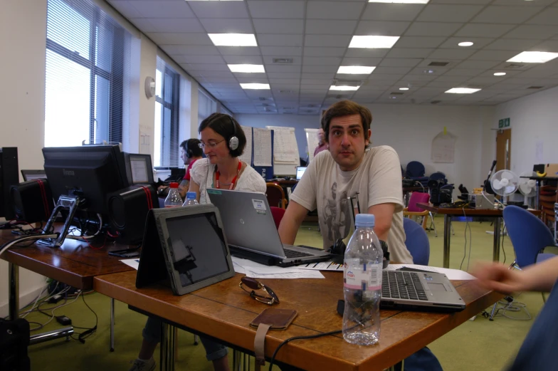 two men sitting at a table using their computers