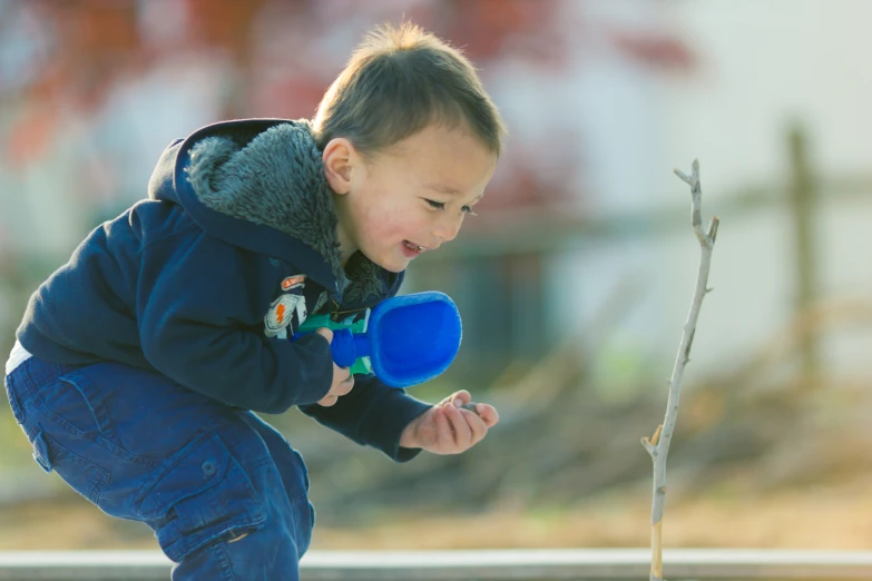 the small boy is throwing a blue frisbee