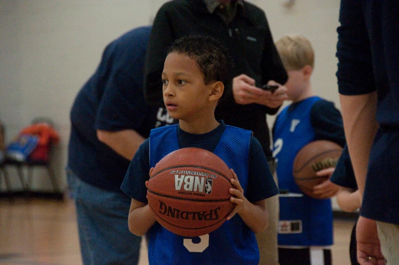 there is a young man holding a basketball in hand