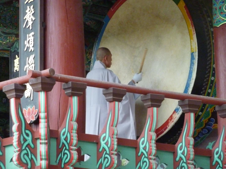 a man in white robe playing the drums and decorations