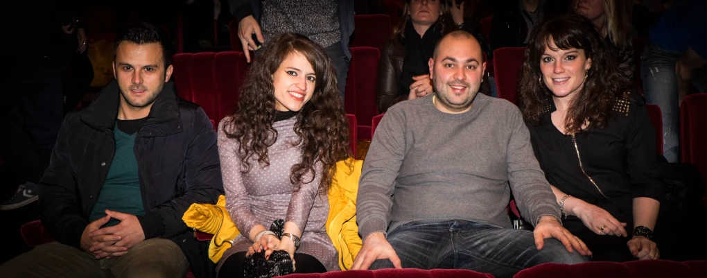 four people in the theater smiling for the camera