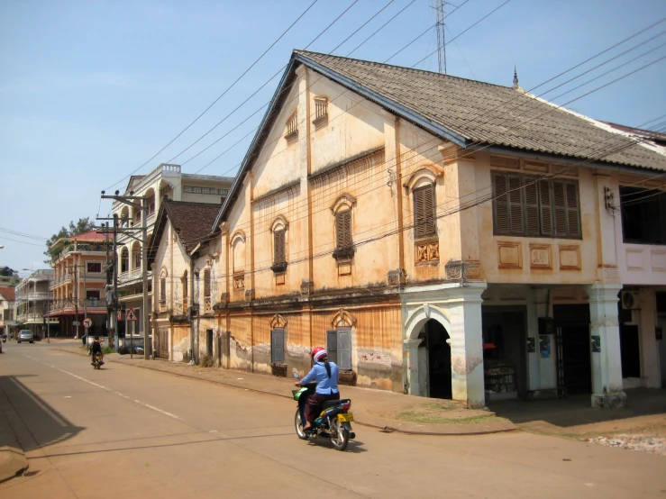 a person riding on the back of a motorcycle down a street