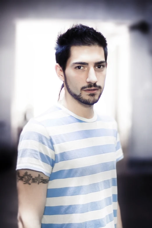 man in white and blue striped shirt standing in a room