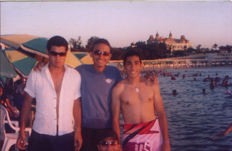 four young men in swim suits on a beach