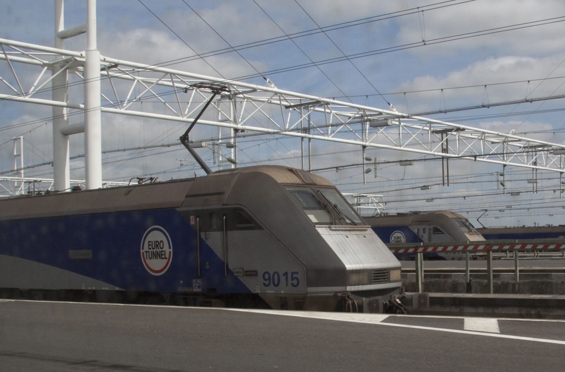 a high speed train traveling along tracks under power lines