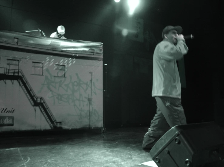 a young man is singing in front of the stage