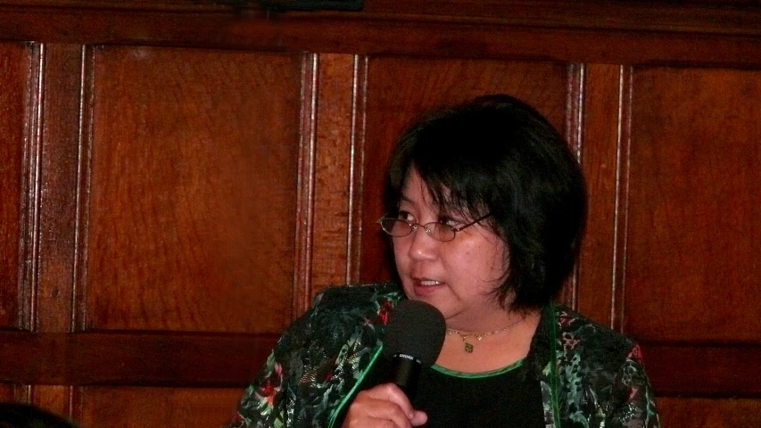 a woman standing with a microphone in her hands