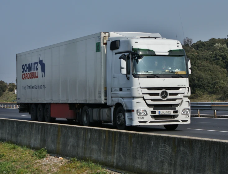 a truck with a semi trailer driving down the road