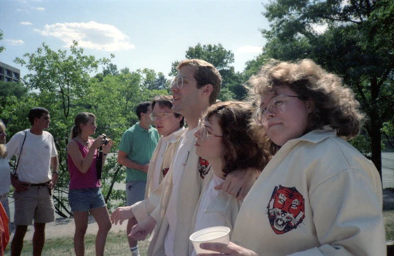 people standing in the grass with cups and flags