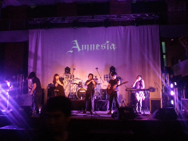 a group of people on stage in front of a sign