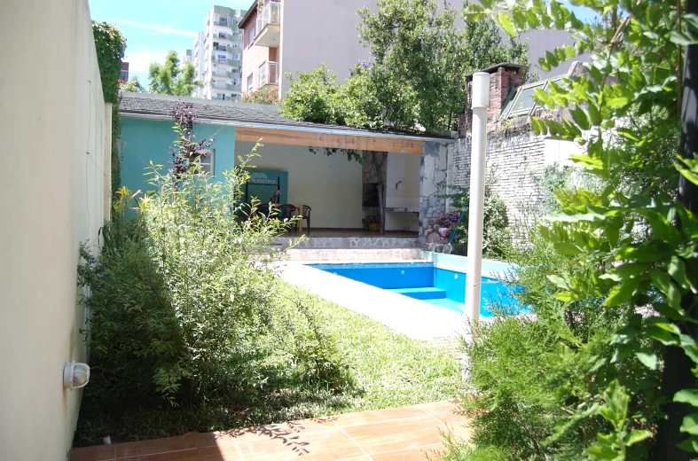 an outdoor pool surrounded by vegetation and building